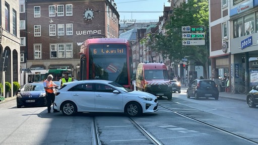 Ein Auto steht quer vor einer Straßenbahn auf den Schienen