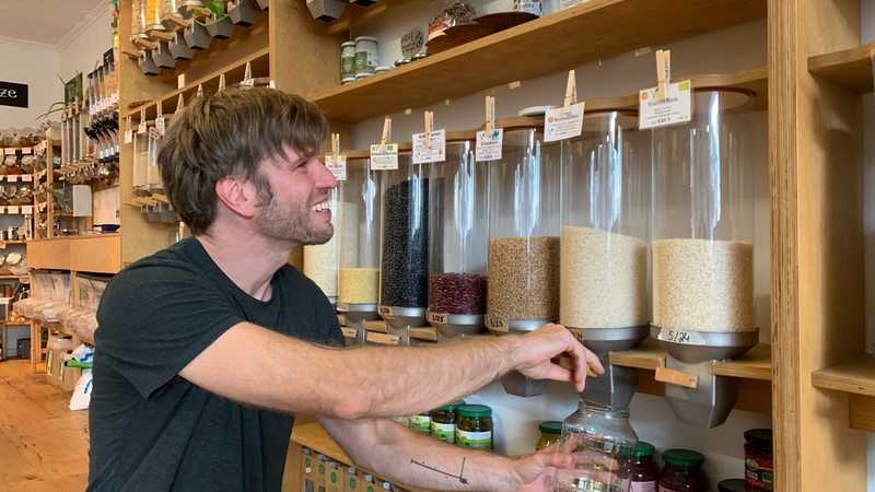 Ein junger Mann füllt sich Reis in ein Glas