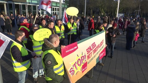 Mehrere Personen stehen bei einem Warnstreik vor der ÖVB-Arena.