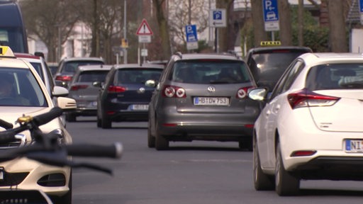 Mehrere Autos fahren hintereinander auf einer Straße.