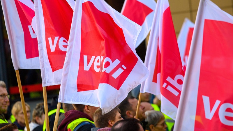 Menschen halten Fahnen mit der Aufschrift "Verdi" in der Hand.