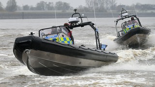 Mitarbeiter der Wasserschutzpolizei Bremen fahren mit ihren Booten auf der Weser.