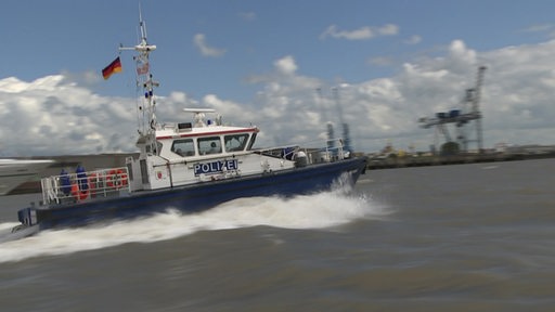 Ein Boot der Polizei fährt durch den Hafen.