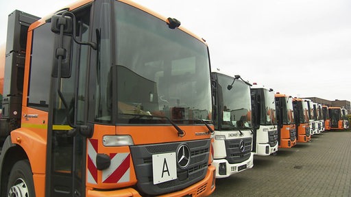 Die fertig produzierten Wasserstoff-LKW´s nebeinander parkend in einer Reihe.