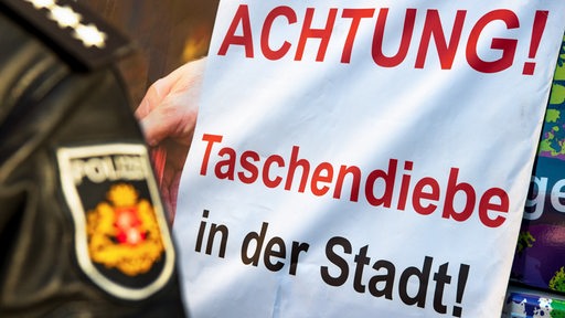 Auf einem Schild steht "Achtung! Taschendiebe in der Stadt!"