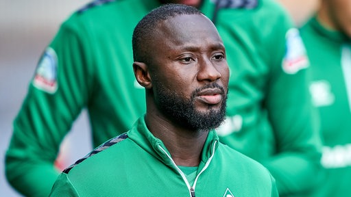 Werder-Neuzugang Naby Keita schaut ernst, während er zum Traininsgplatz schlendert.