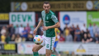 Werder-Spieler Maik Lukowicz blickt auf den Ball.