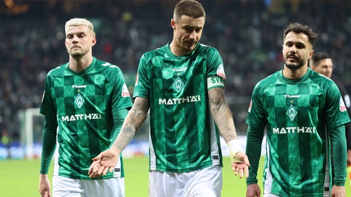 Werder-Kapitän Marco Friedl verlässt unzufrieden gestikulierend nach dem Remis gegen Stuttgart das Spielfeld, neben ihm Marvin Ducksch und Leonardo Bittencourt.