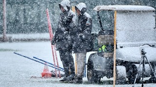 Peter Niemeyer und Clemens Fritz schauen vom Rand zu, als Werders Team im Schnee trainiert.