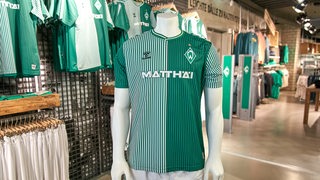 Die neuen Werder-Heimtrikots hängen im Fanshop an Kleiderbügeln und wurden einer Schaufensterpuppe übergezogen.