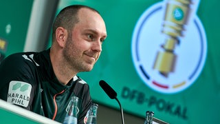 Ole Werner (Cheftrainer SV Werder Bremen) am Podium im Medienraum während der Pressekonferenz vor dem anstehenden Spiel um den DFB-Pokal. 