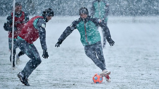 Senne Lynen versuchrt Niklas Stark beim Training im Schnee auszudribbeln.