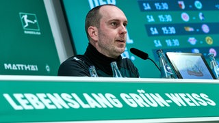 Ole Werner sitzt auf dem Podium und beantwortet Fragen auf der Pressekonferenz. 