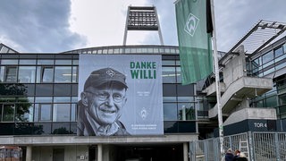 Auf einem Banner an der Fassade des Weser-Stadions steht "Danke Willi". Daneben ist das Konterfei von Willi Lemke zu sehen. 