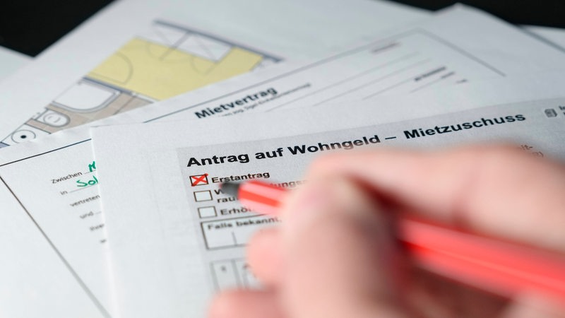 Hand beim Ausfüllen eines Antrag zur Erlangung von Wohngeld